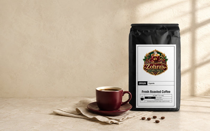 Zohra's Coffee Shop Uganda single origin fresh roasted coffee bag beside a maroon cup of black coffee in morning light