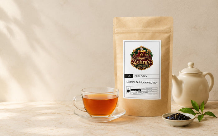 Zohra's Coffee Shop Earl Grey loose leaf tea pouch with a glass cup of brewed tea and a cream teapot